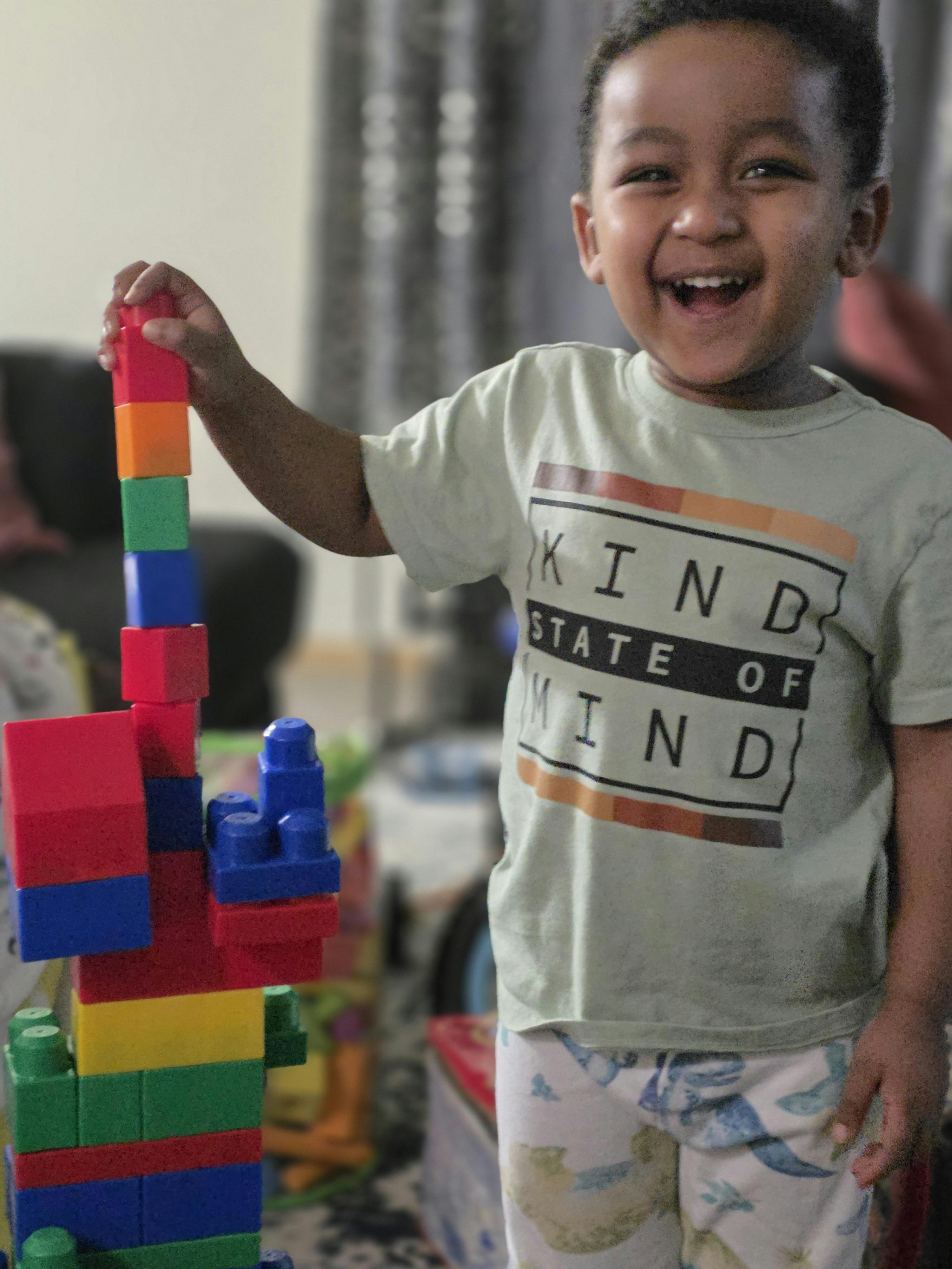 Child building a tall structure with colorful blocks