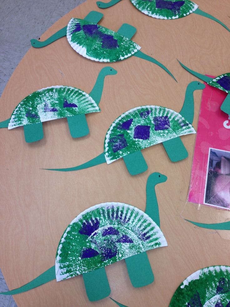 Paper plate dinosaur crafts with green and purple paint