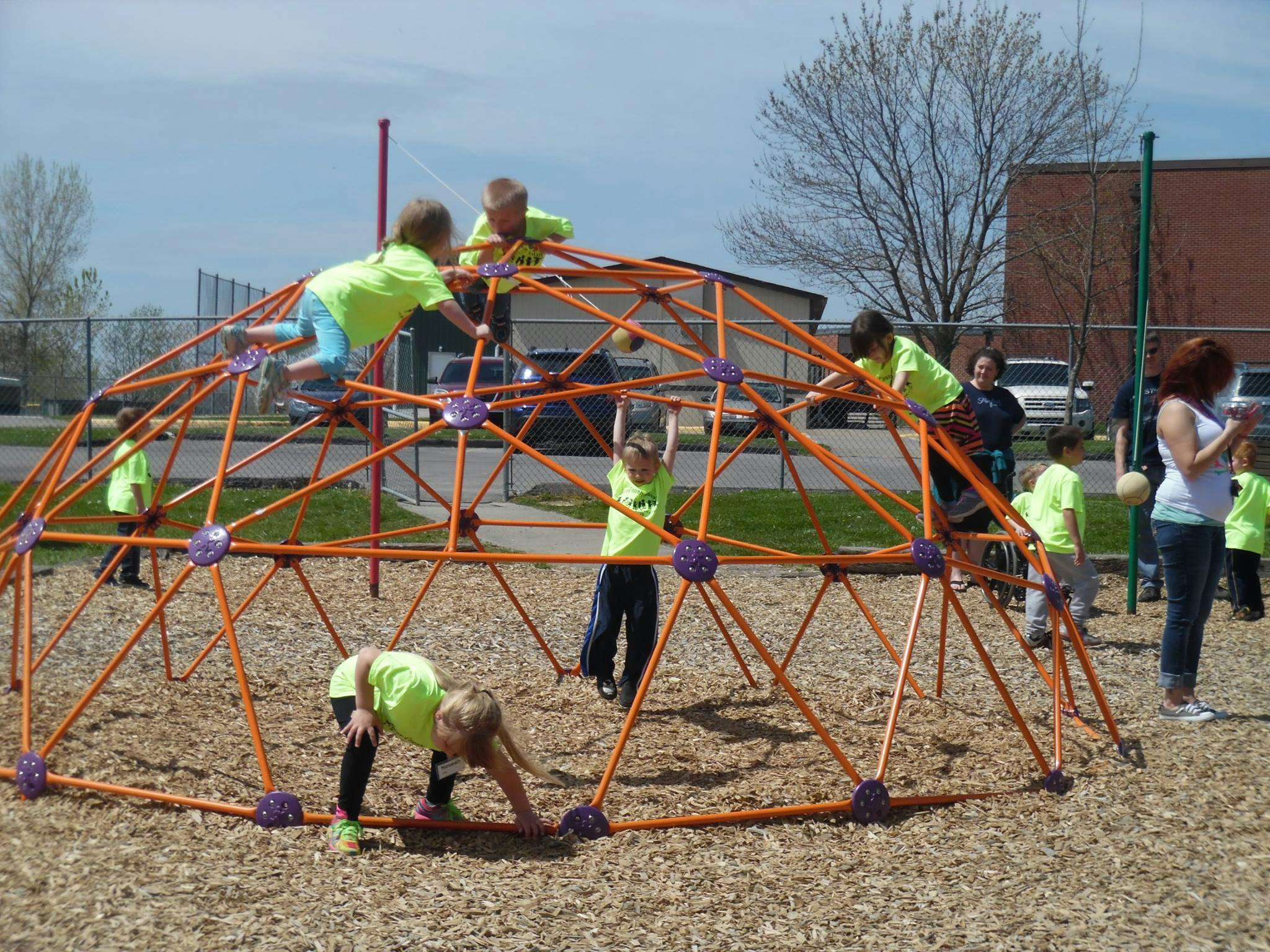 Children climbing on a geodesic dome playground structure