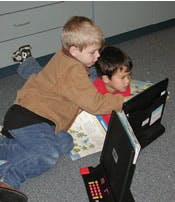 Two children looking at a laptop