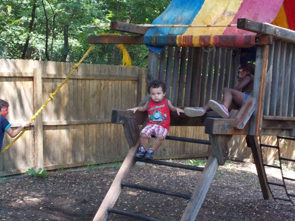 Children playing on a wooden playground structure
