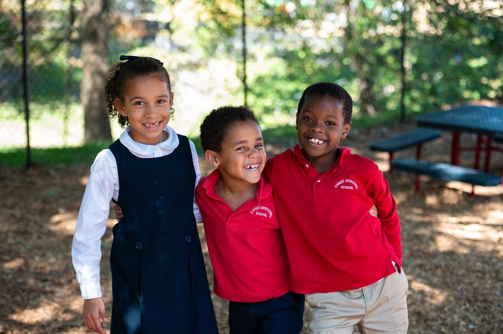 Three children standing together outdoors