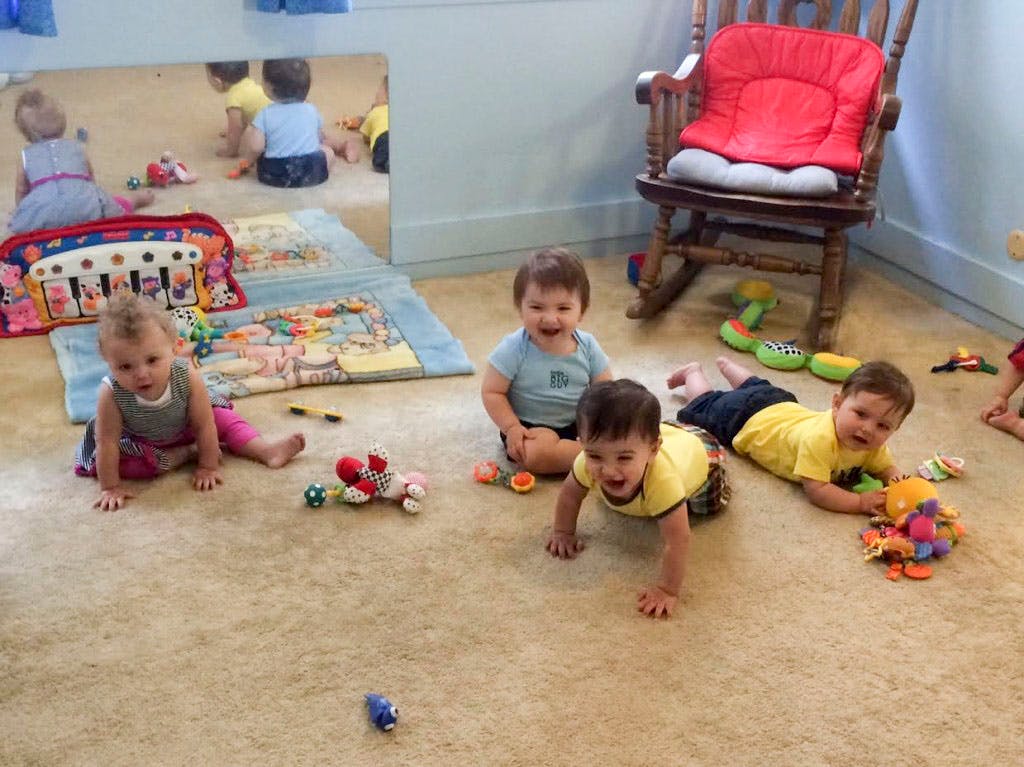Multiple children playing on the floor with toys