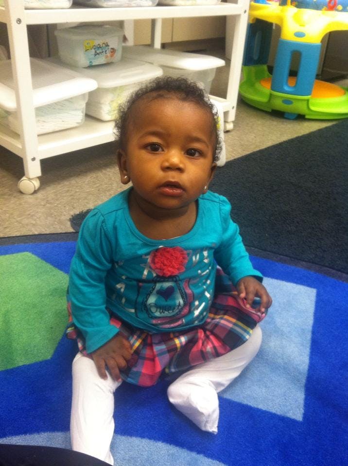 Child sitting on a blue mat