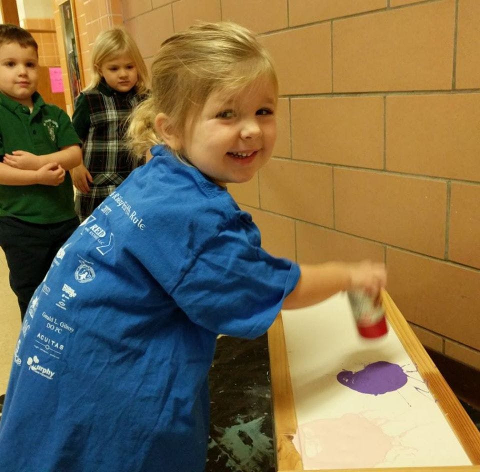 Child painting with purple paint