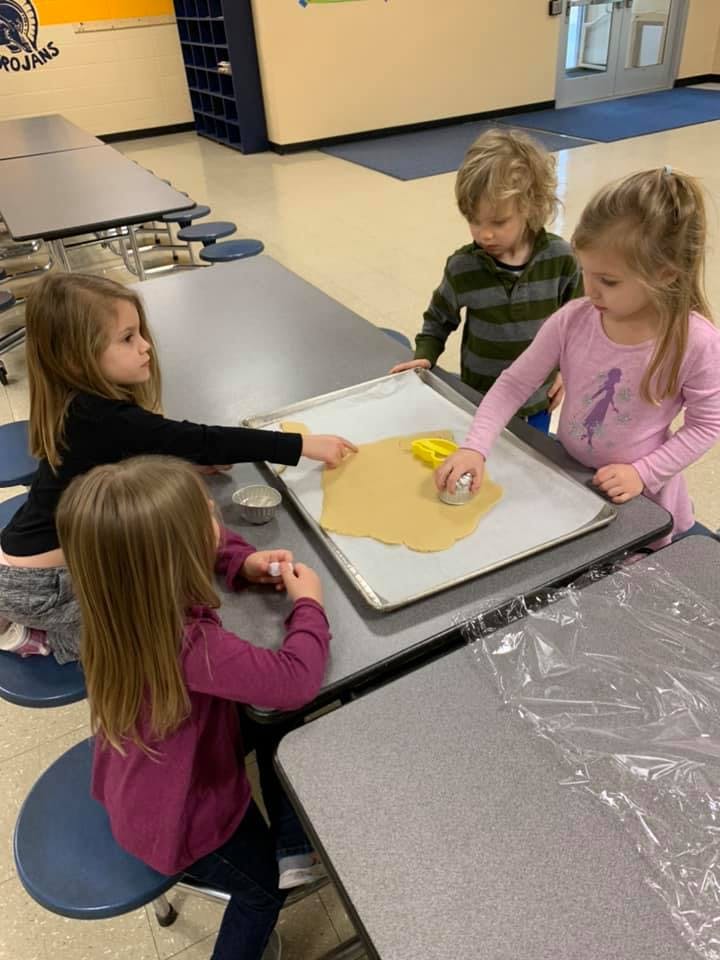 Four children making cookies at a table