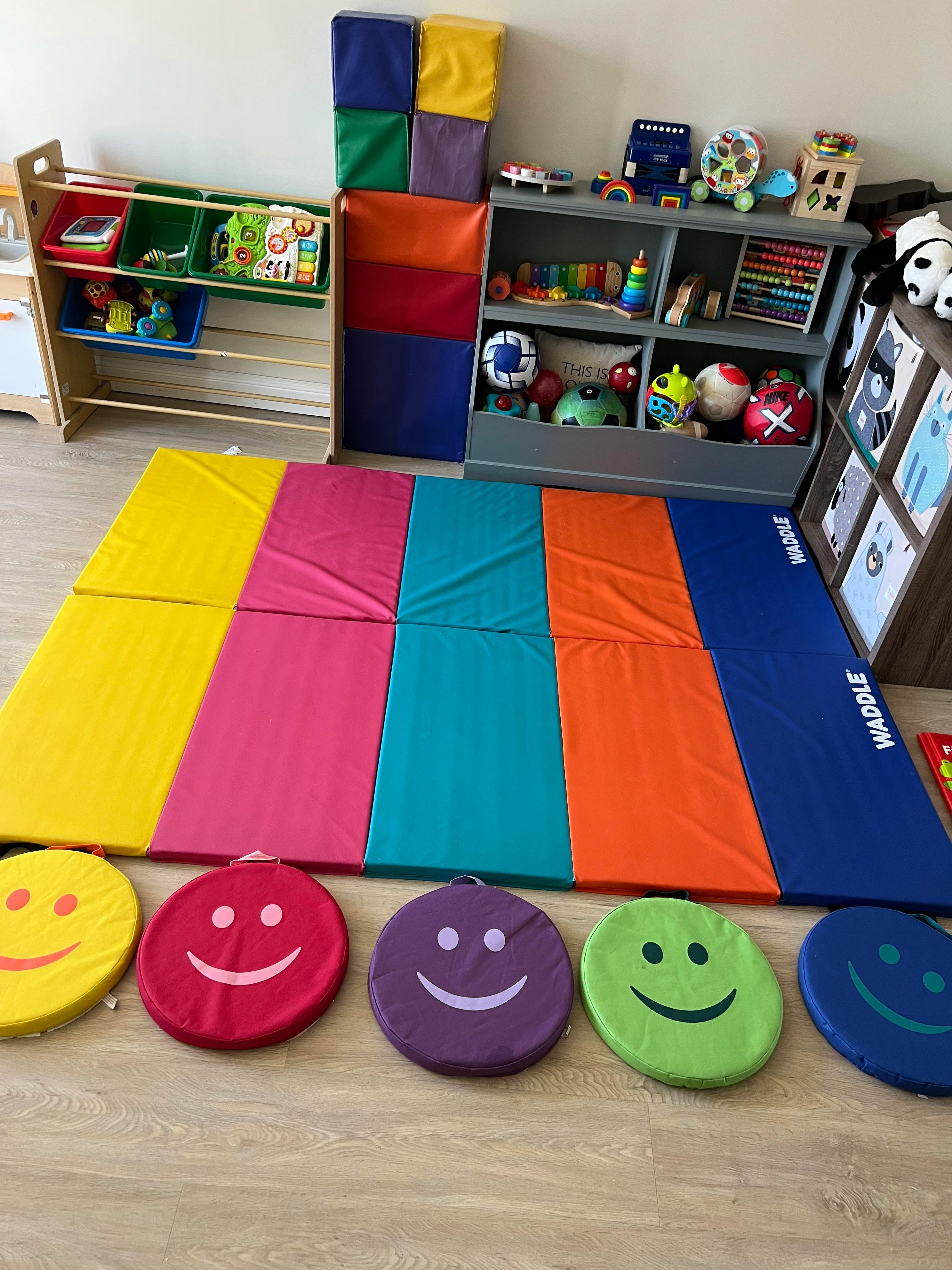 Colorful playmats and round cushions with smiley faces in a playroom