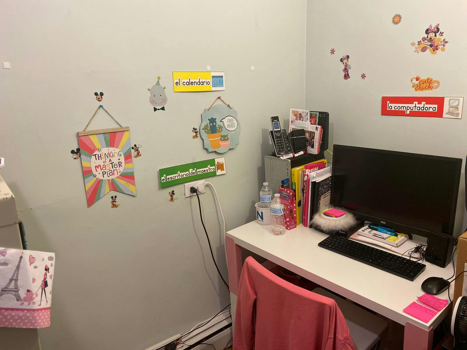 Desk with a computer monitor, keyboard, mouse, and books in a corner