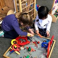 Two children playing with toys on a table