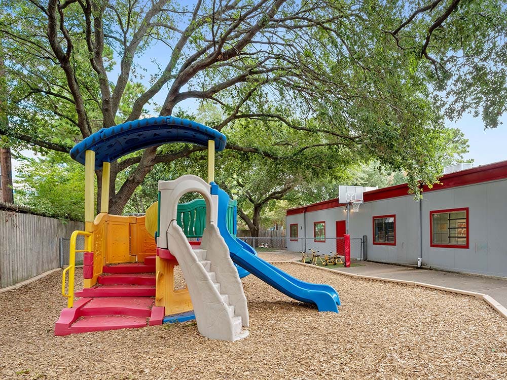 Playground with swings, slides, stairs, and a basketball hoop