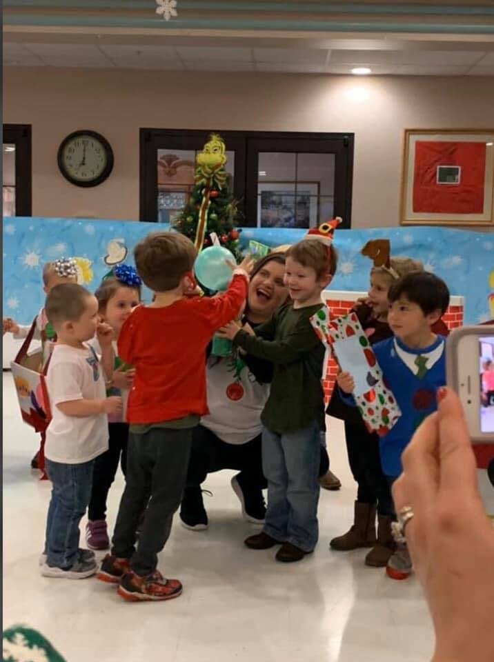 Adult and children gathered around a Christmas tree