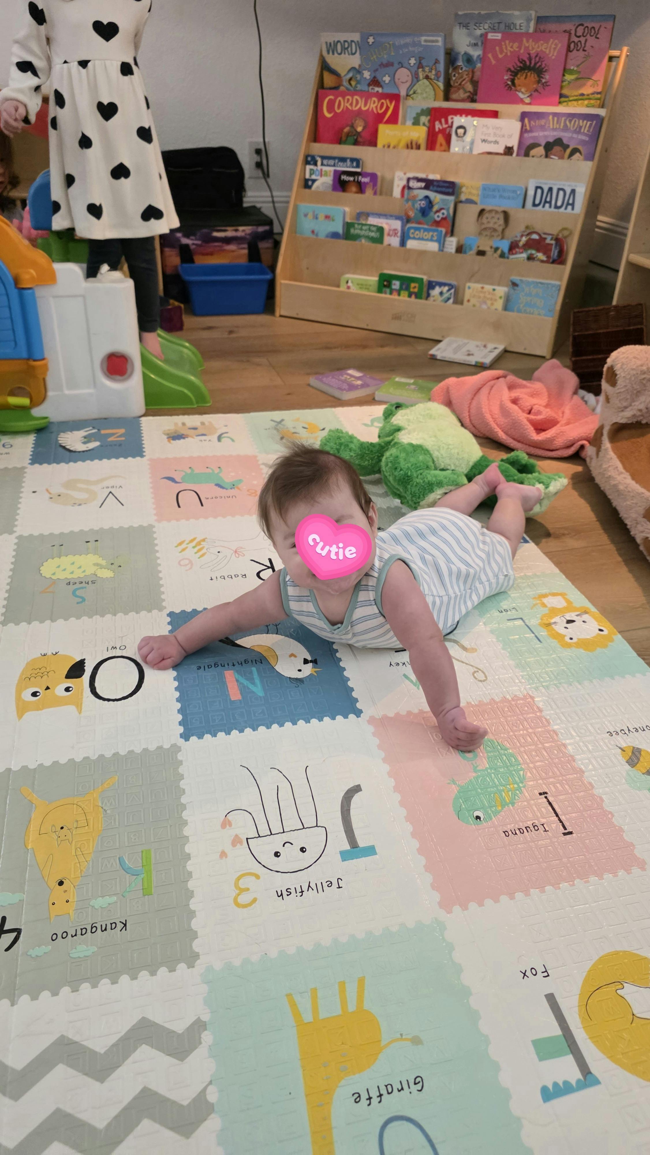 Child on stomach on a colorful playmat