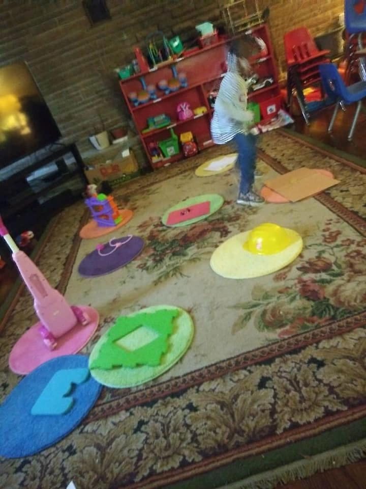 Child standing on a rug with colorful floor mats
