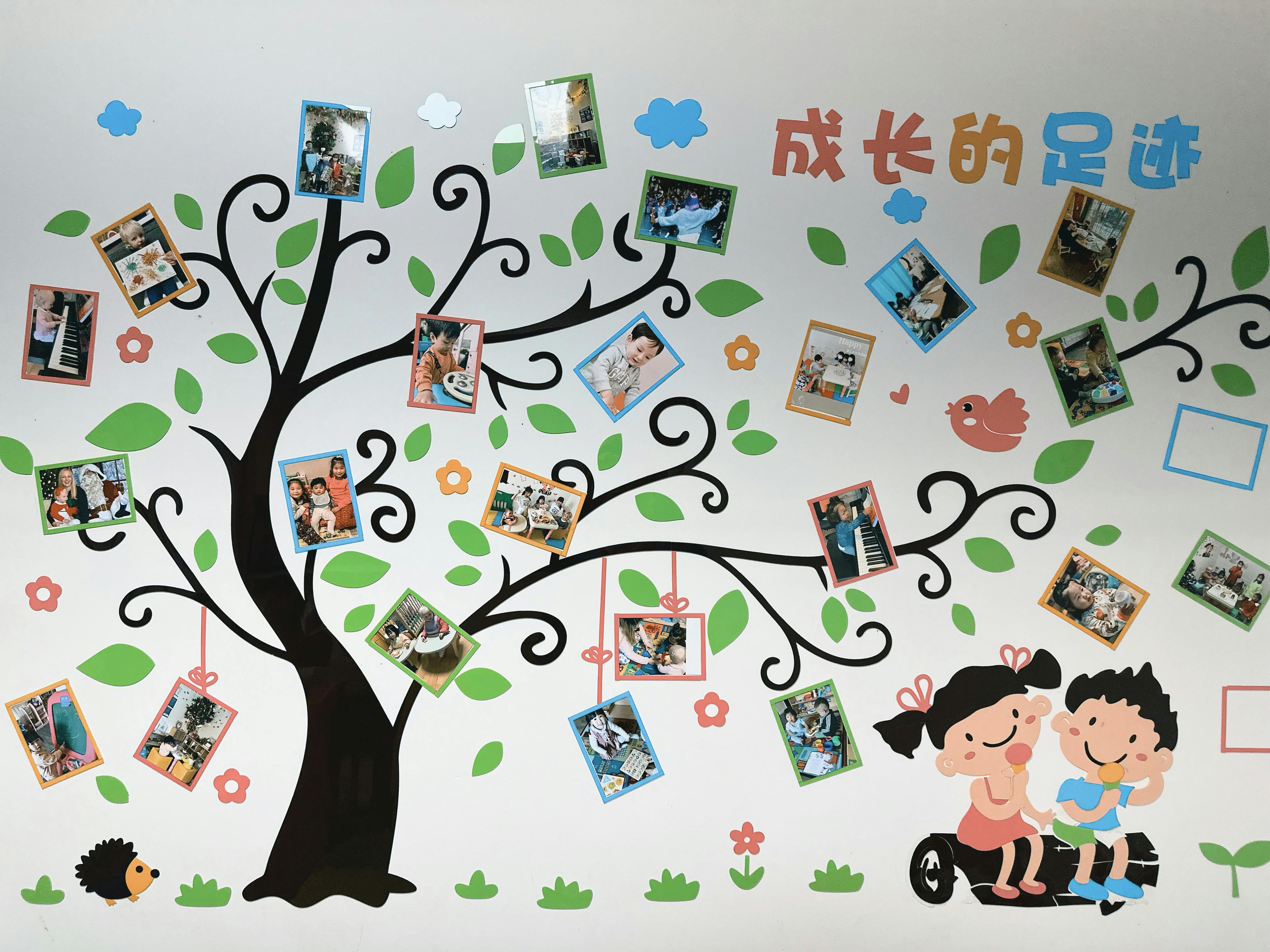 Wall decal of a tree with photos and cartoon children