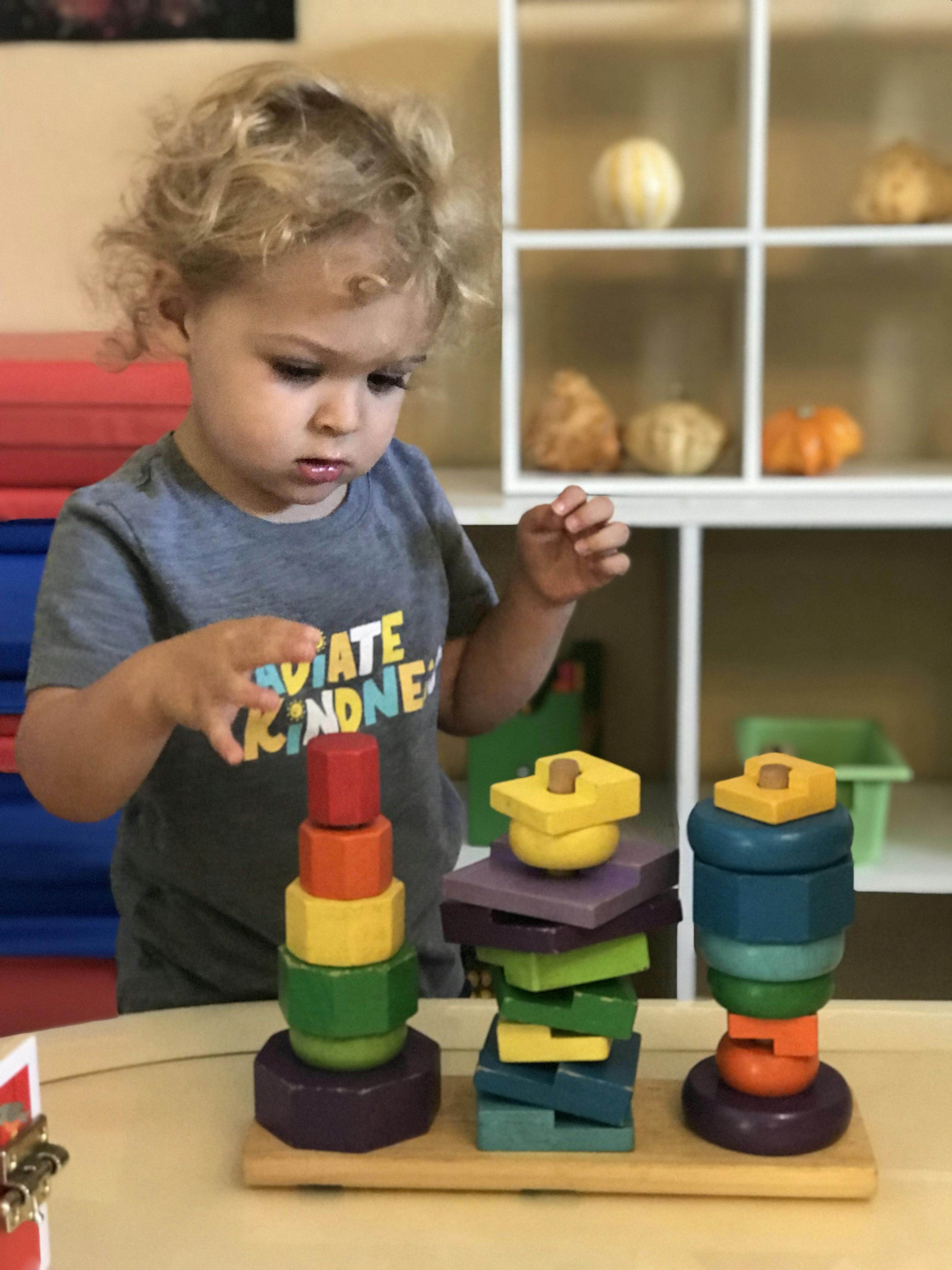 Child playing with colorful stacking toys