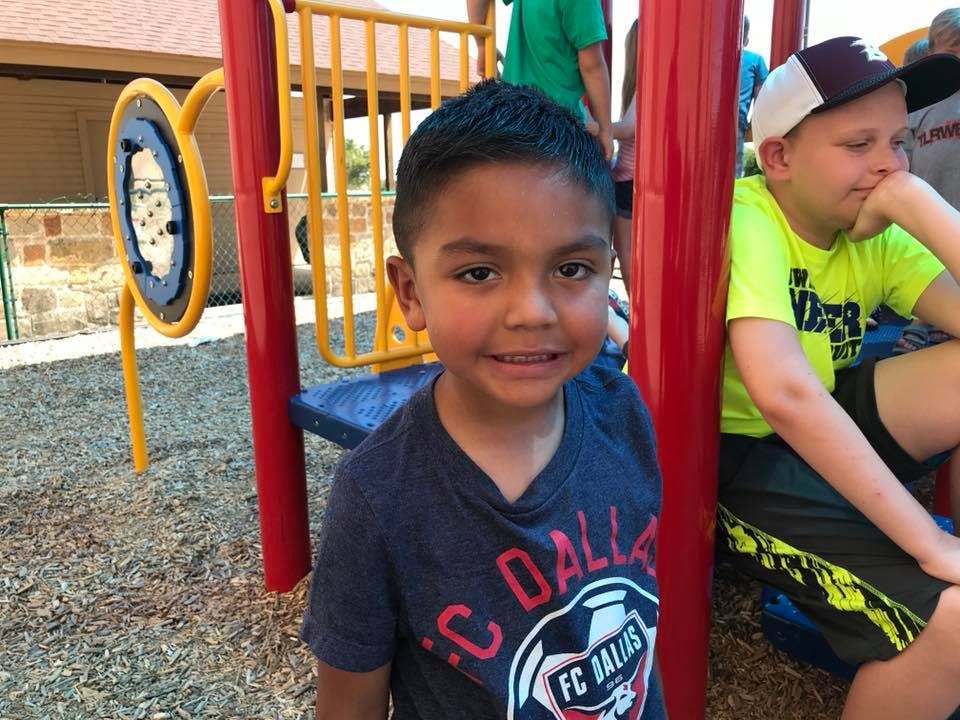 Child in a blue shirt on a playground