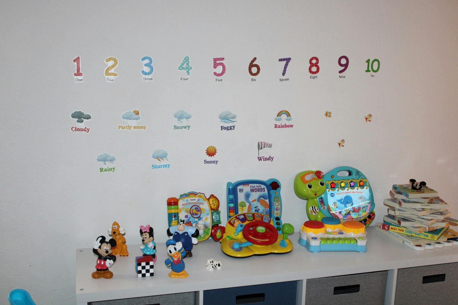 Wall with numbers 1-10 and various toys on a shelf below