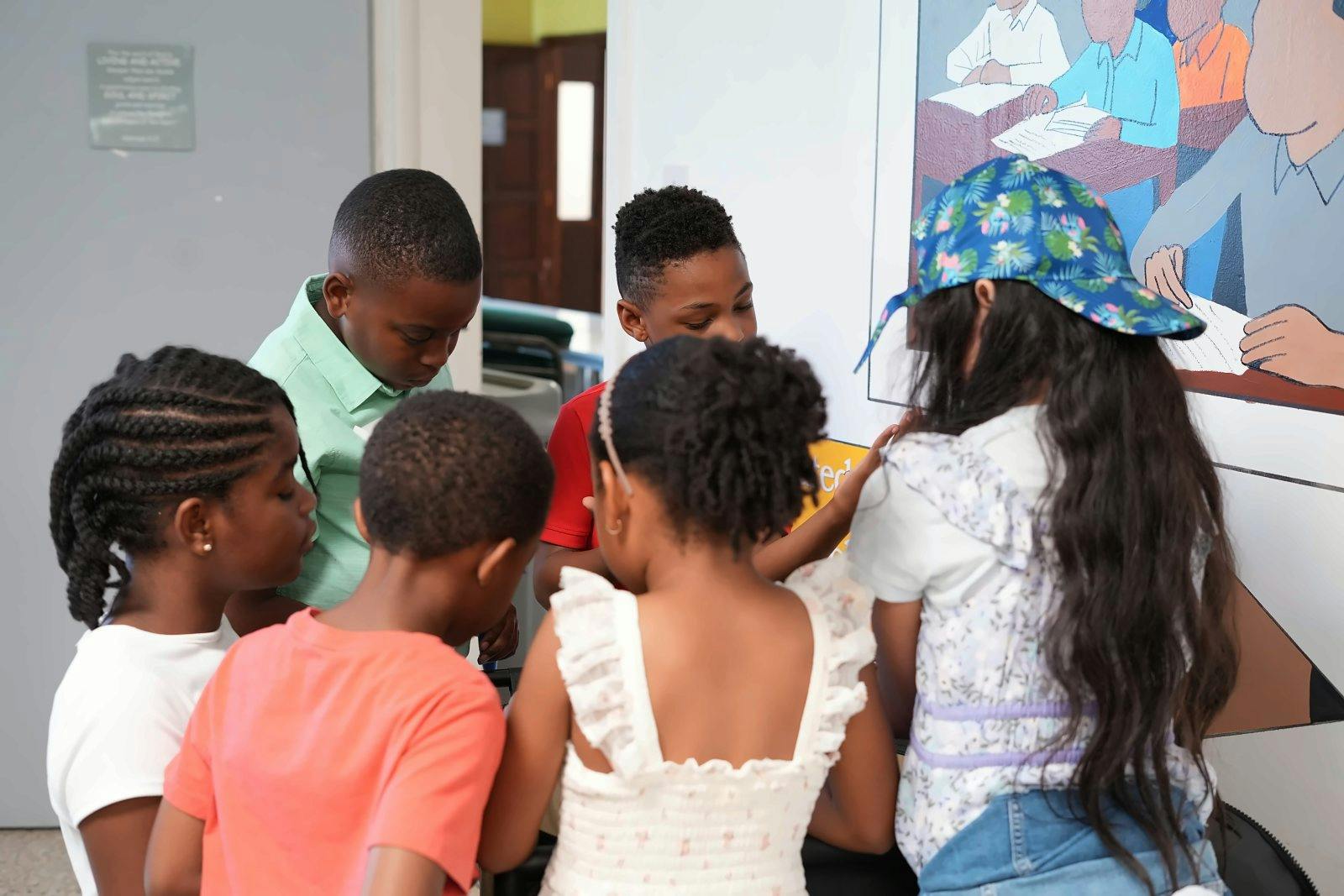 Group of children gathered around an activity in an indoor setting