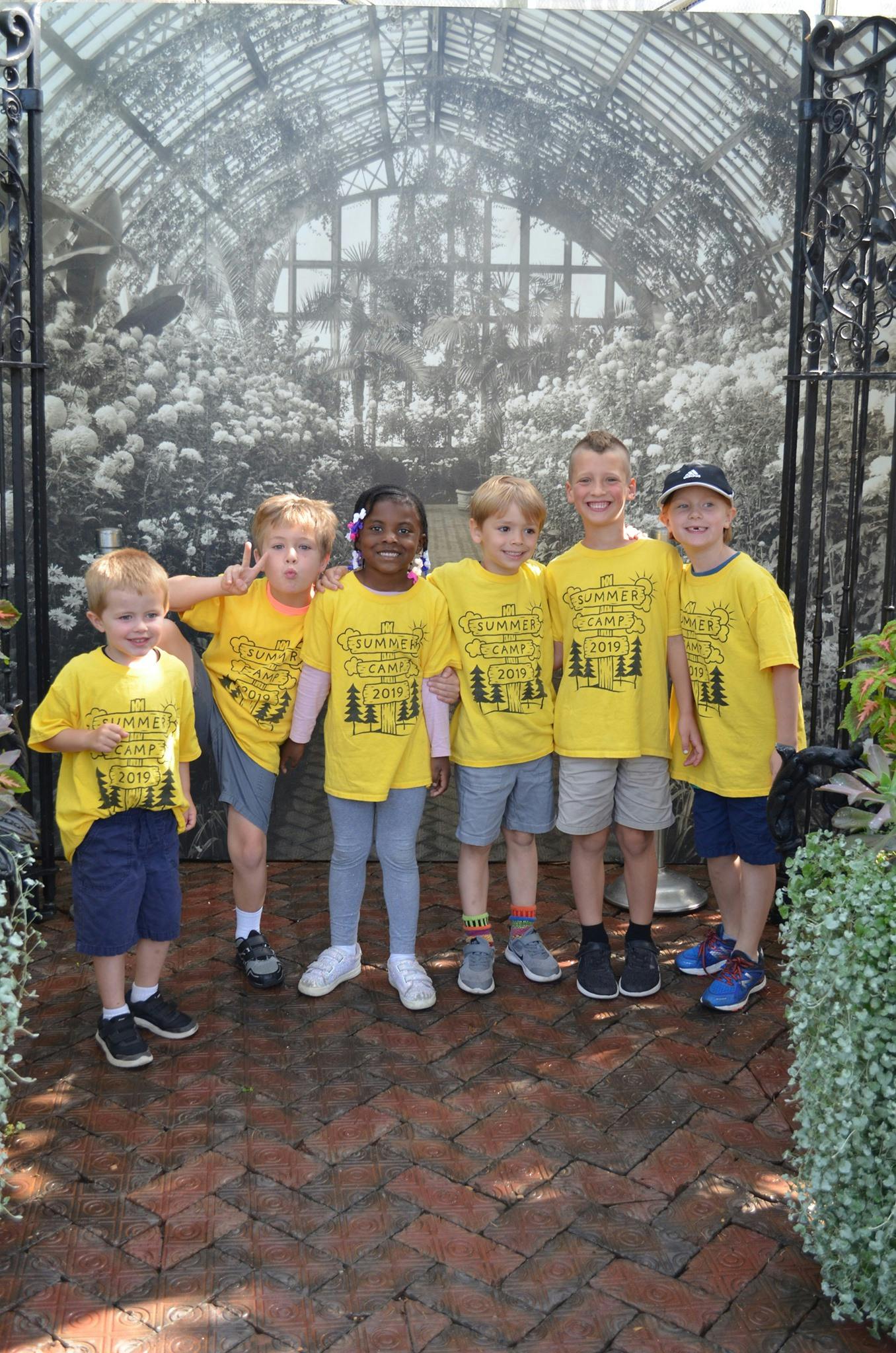 Six children in yellow shirts standing together