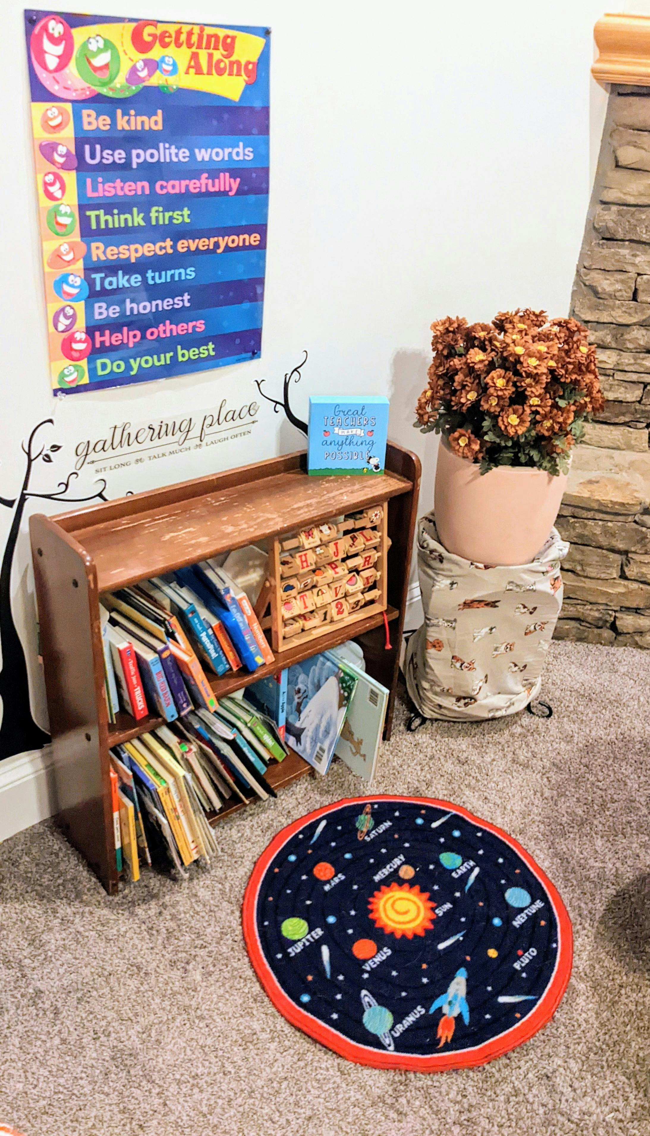 Bookshelf with books, a space-themed rug, and a "Getting Along" poster