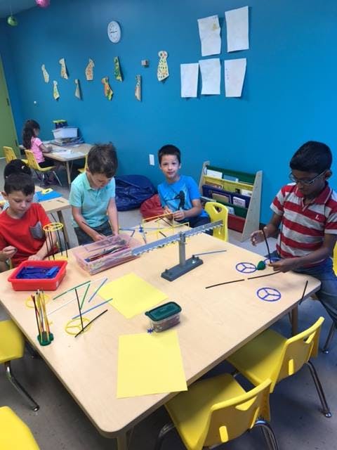 Children at tables working with building materials