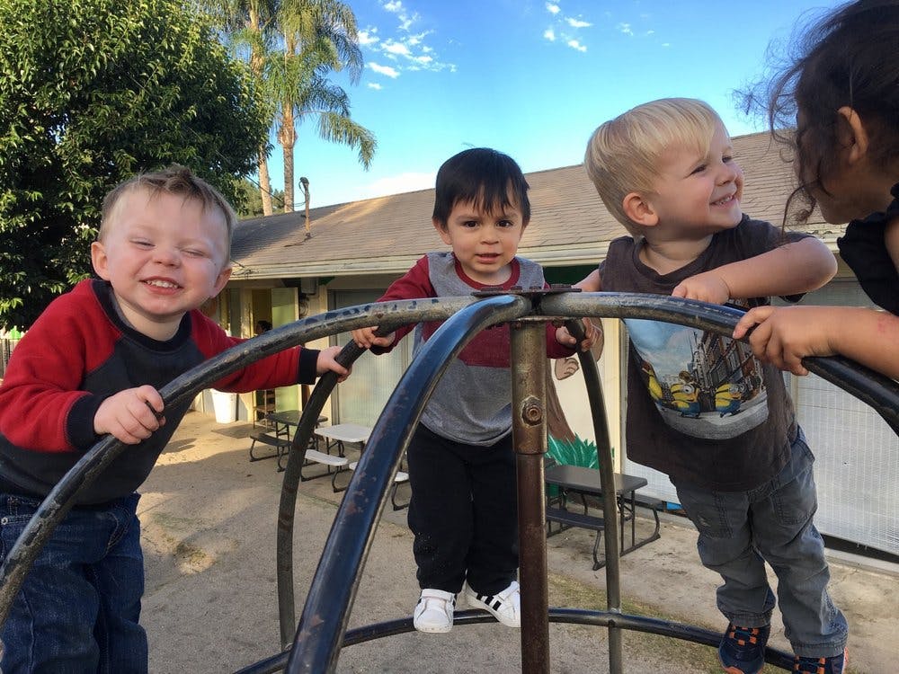 Four children playing on a metal structure outdoors