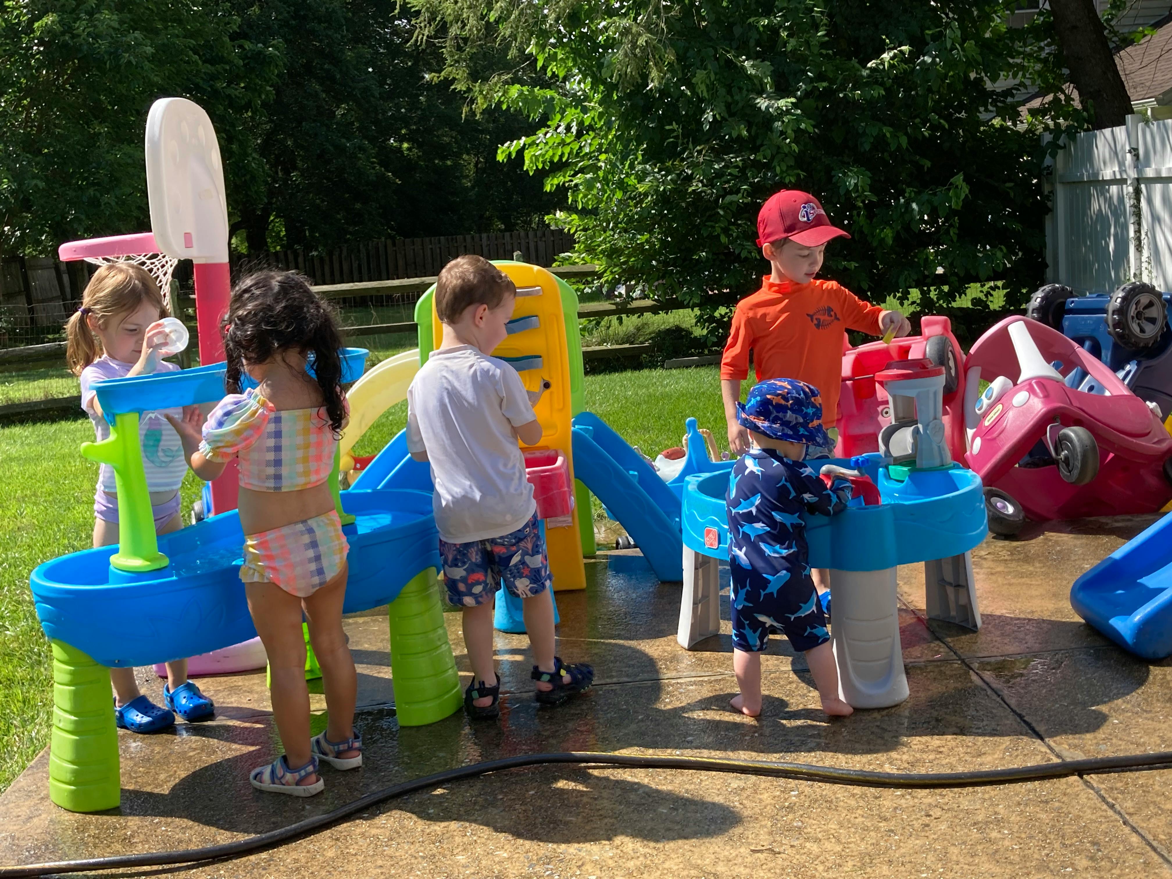 Children playing with water tables and outdoor toys