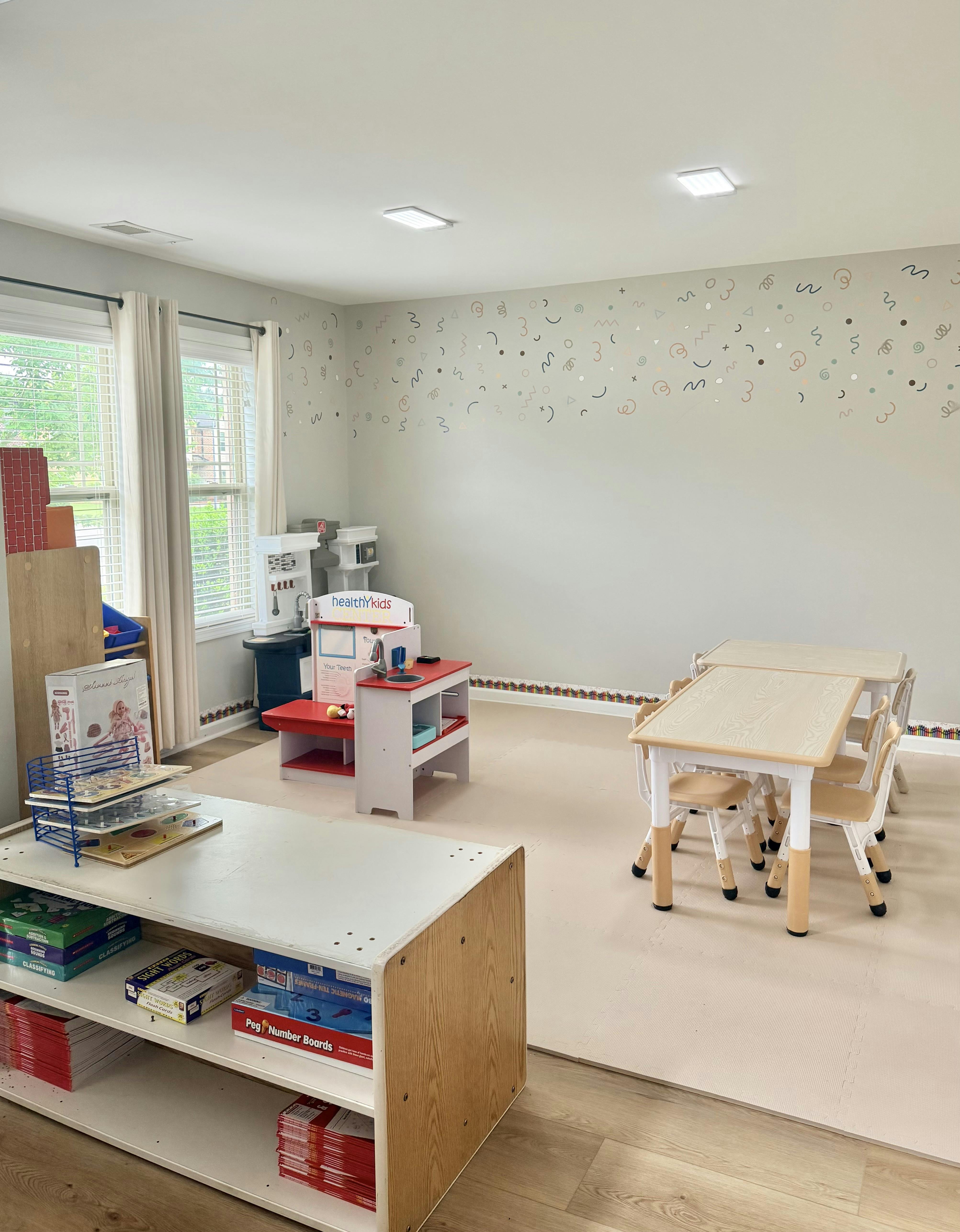 Playroom with tables and toy kitchen