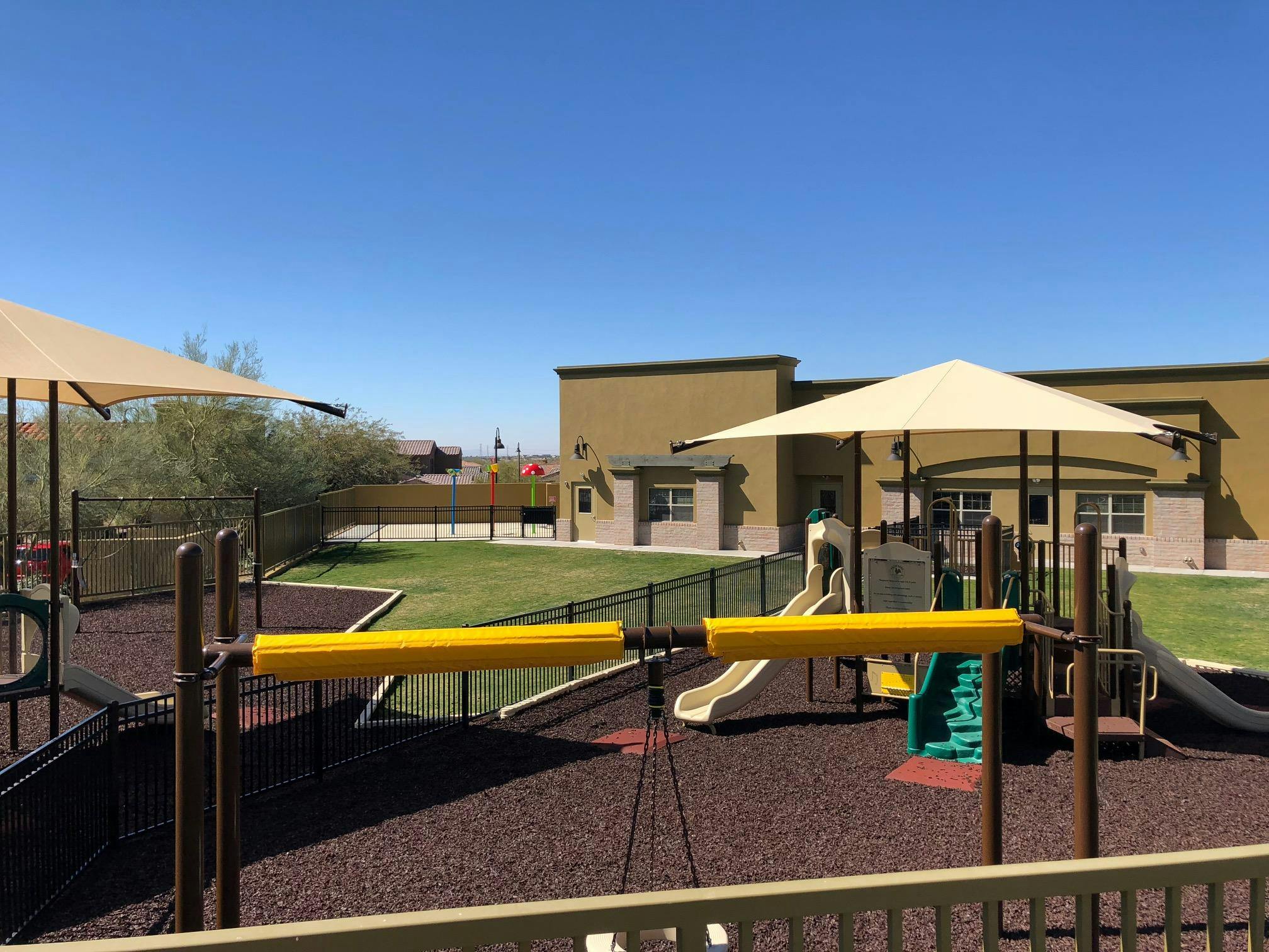 Playground with slides and climbing structures under shade covers