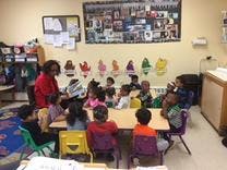 Adult and children sitting at a table in a classroom