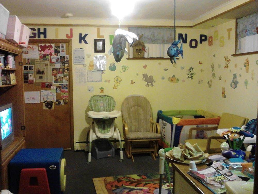 Nursery room with a crib, high chair, and rocking chair