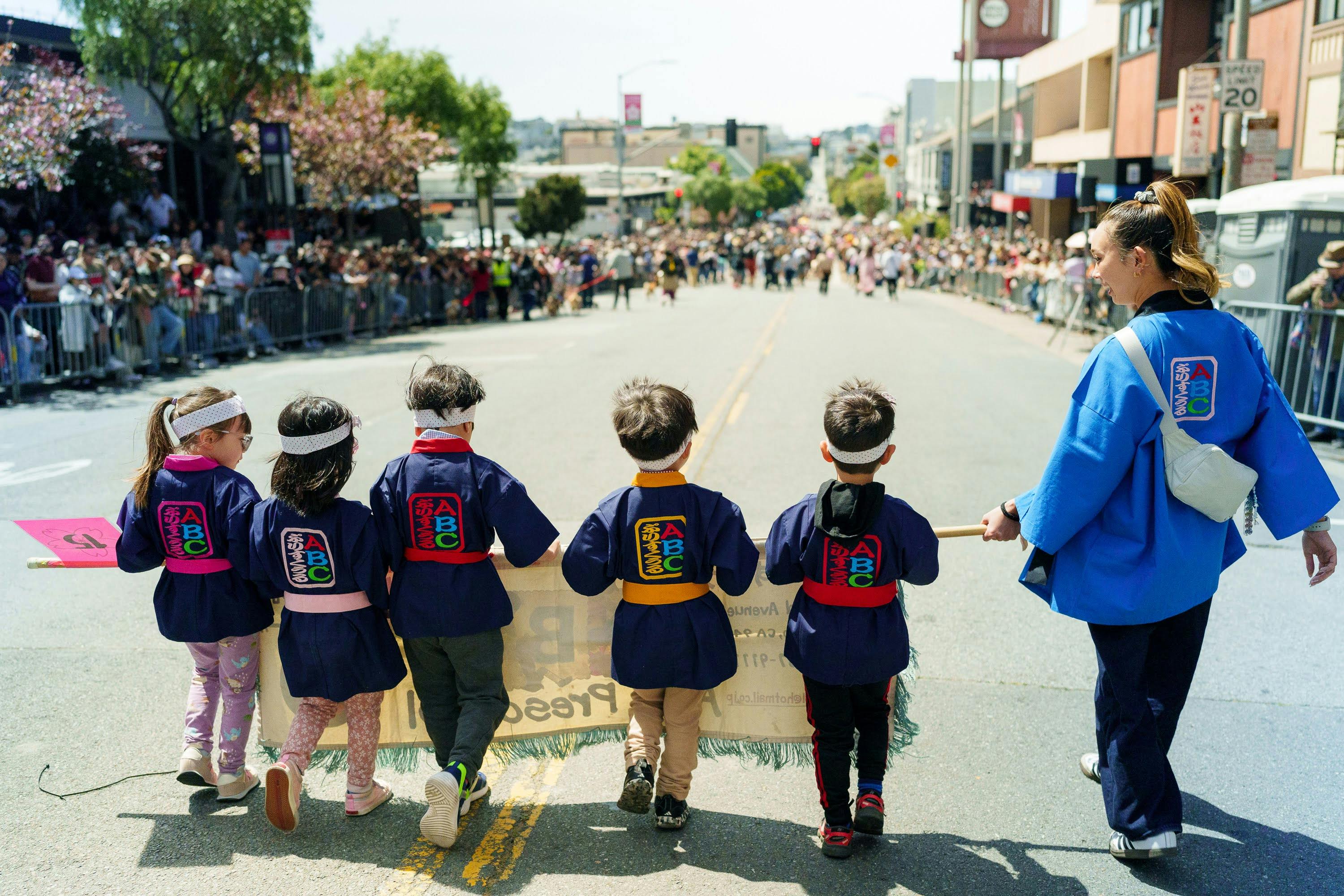 Group of children and an adult carrying a banner in a street parade