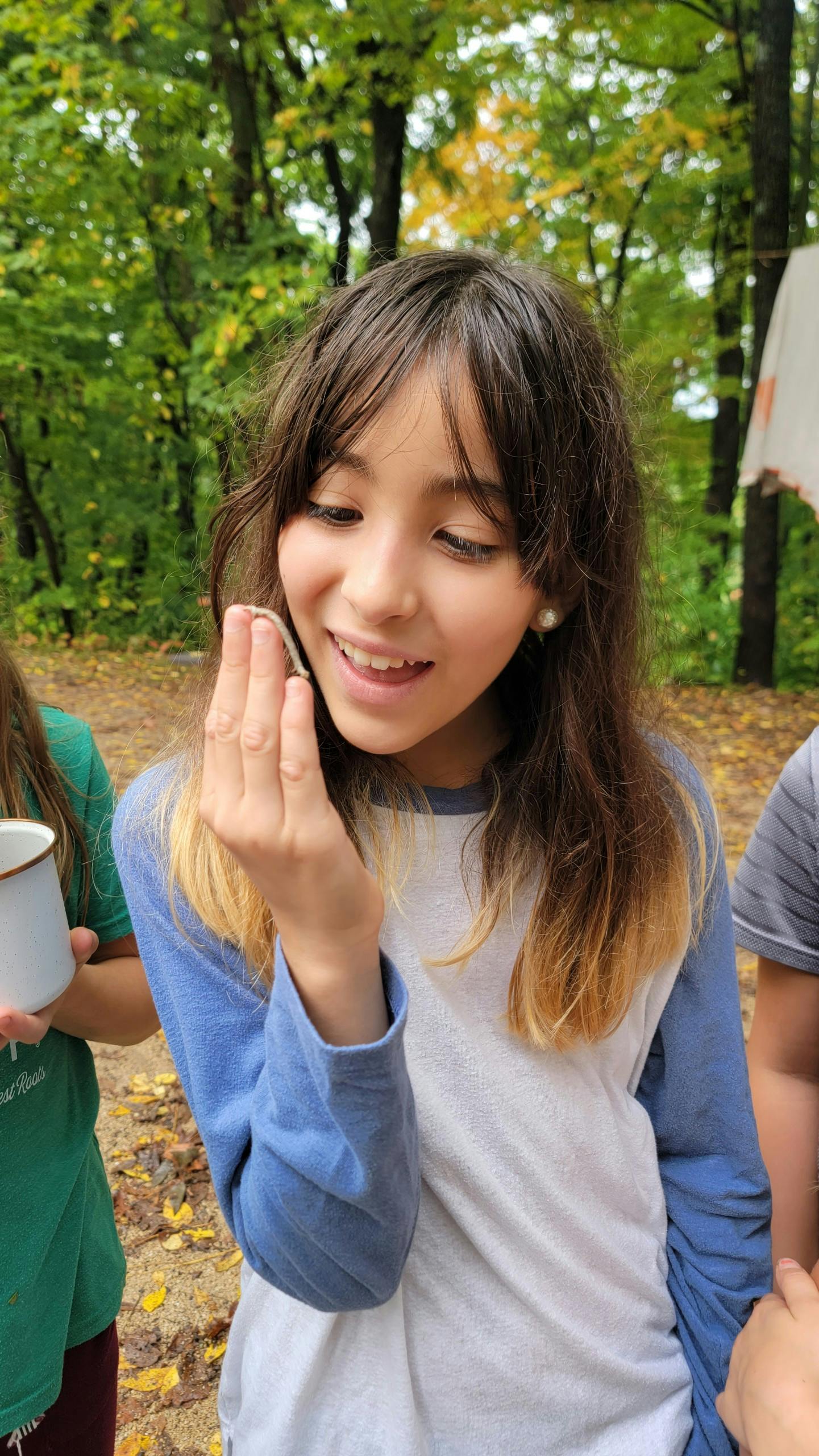 Child holding a small object to their face
