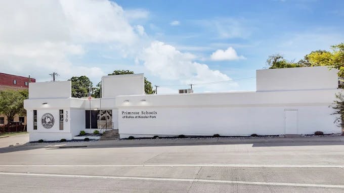 White building with a sign on the left and text on the right