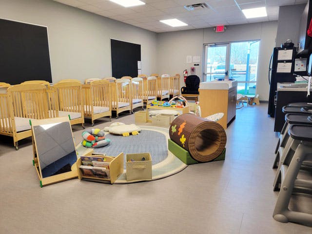 Nursery room with multiple cribs and a play area with a tunnel and a tunnel