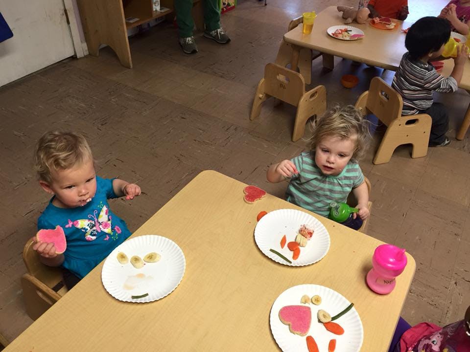 Two children sitting at a table with plates of food