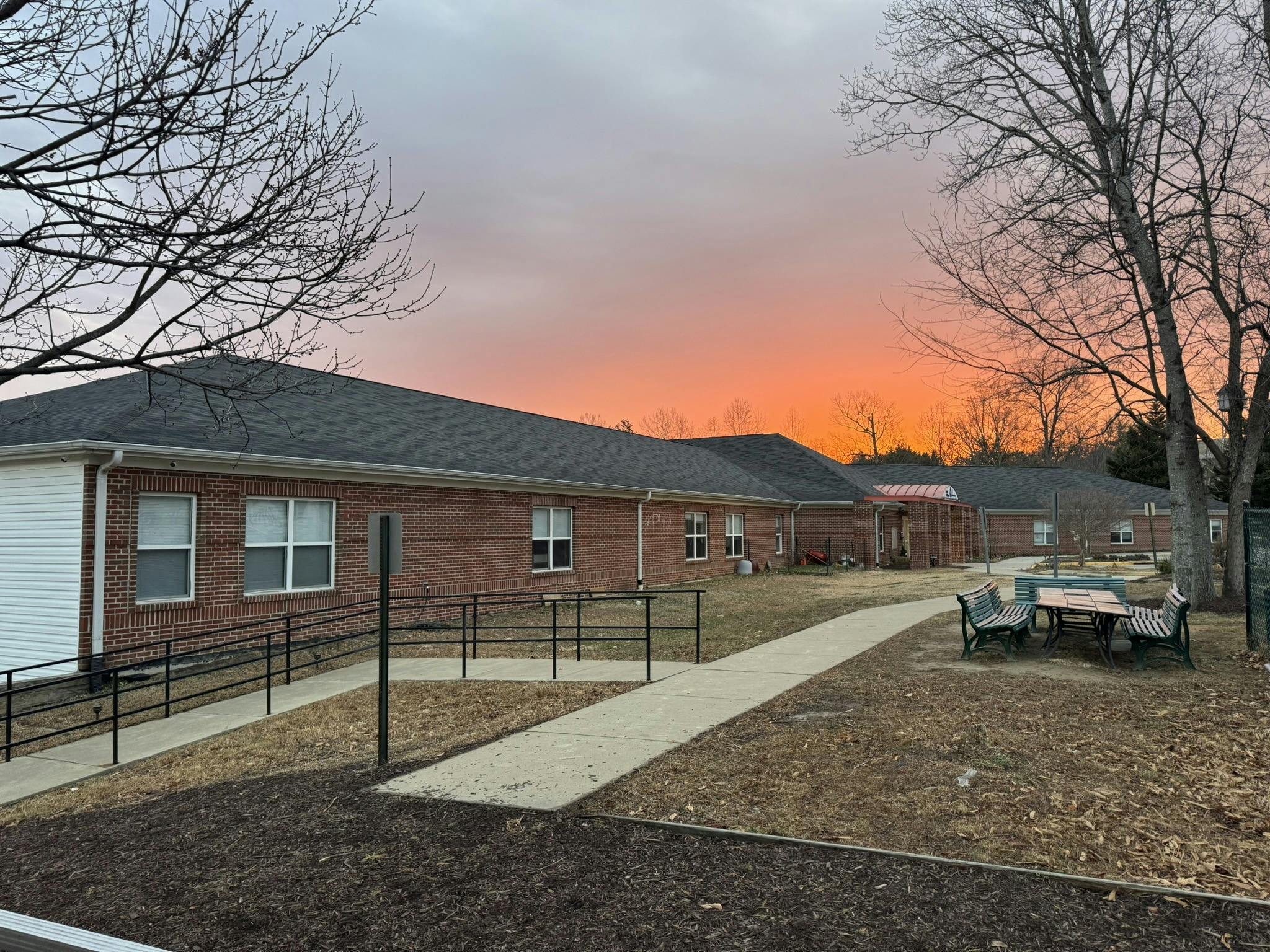 Brick building at sunset with an orange and pink sky