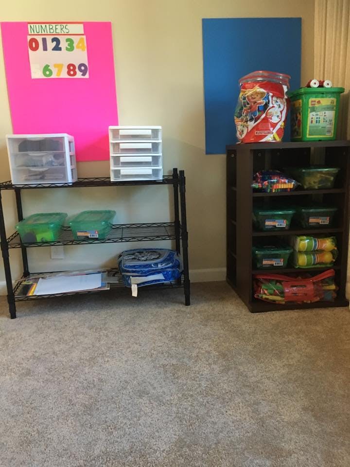 Shelves with storage containers and a numbers chart on a wall