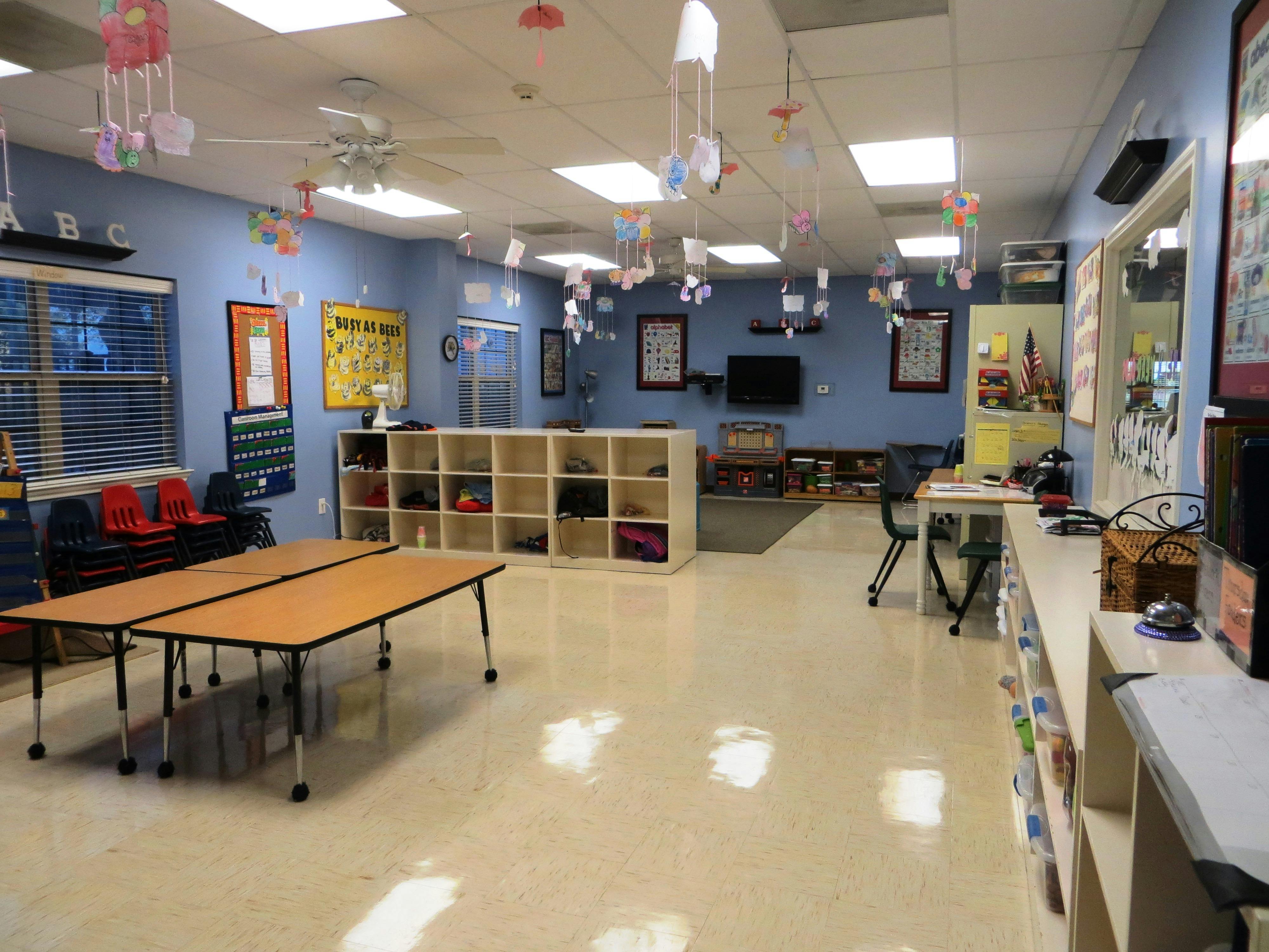 Classroom with tables, cubbies, and decorations hanging decorations