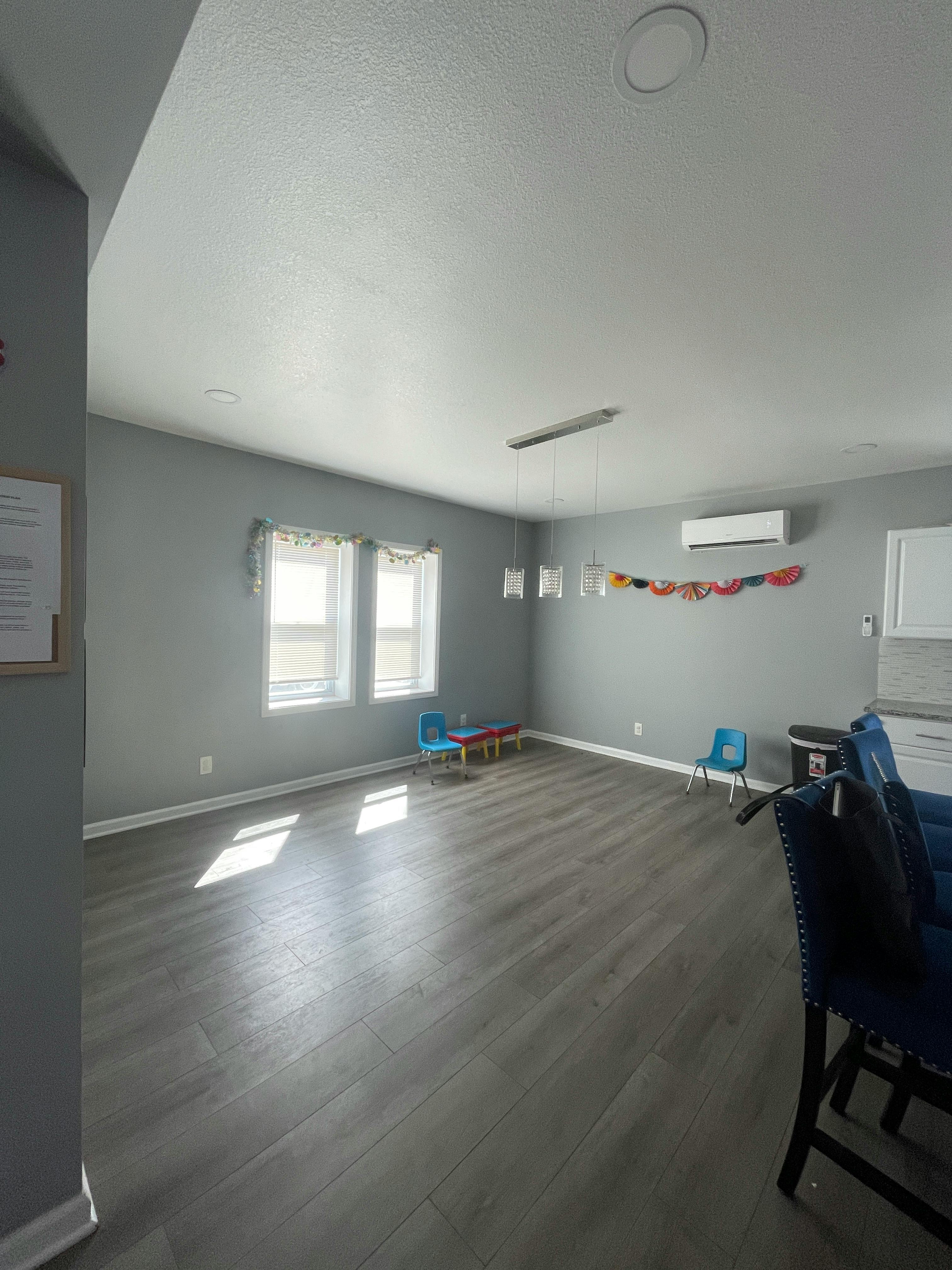 Empty room with gray walls and wood floor, small table and chairs