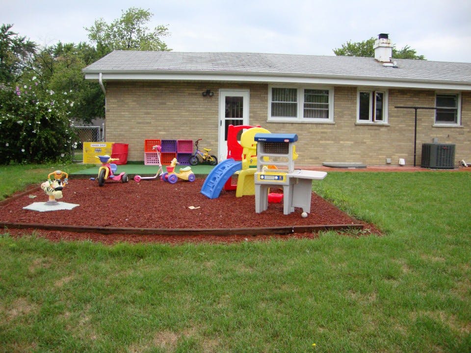 Outdoor play area with various colorful toys and a small slide