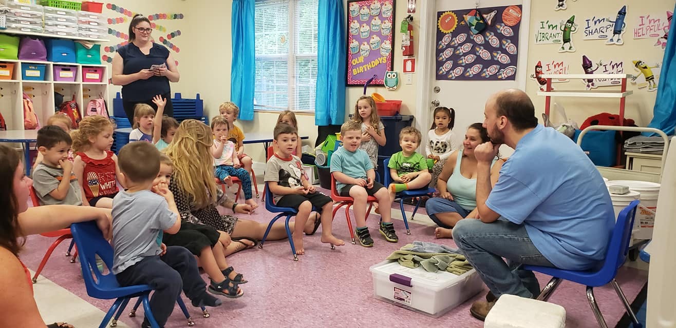 Adults and children sitting in a classroom
