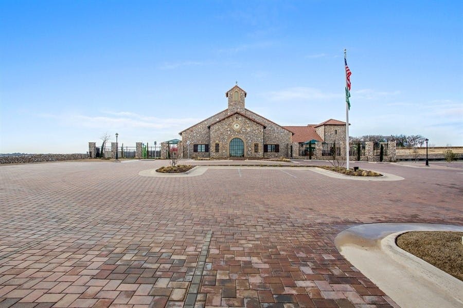 Stone building with a bell tower and a flagpole in front