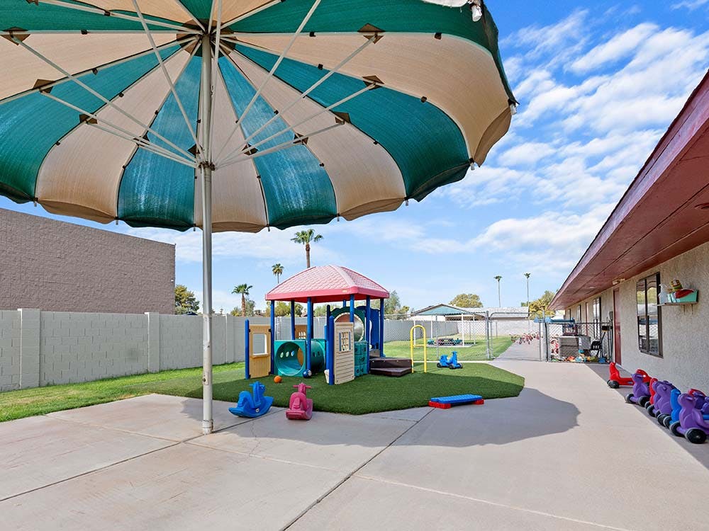 Outdoor playground with play structure and umbrella