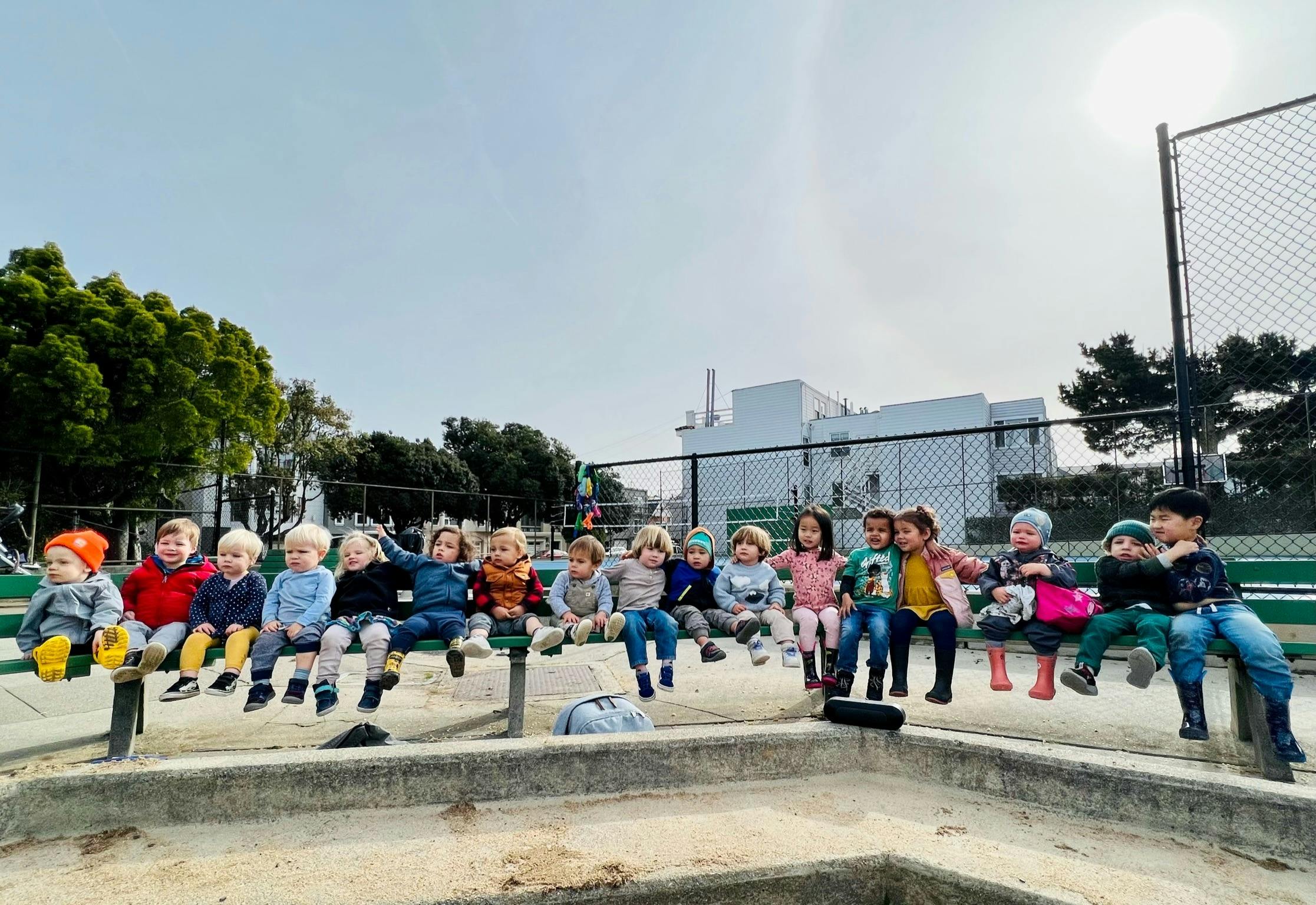 Group of children sitting on a bench outdoors