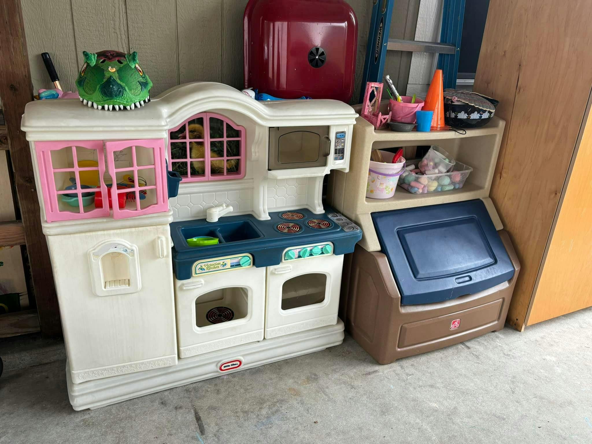 Plastic toy kitchen set with a red toy safe and storage unit