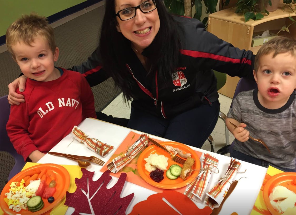 Person with two children at a table with plates of food