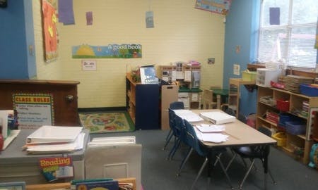 Empty classroom with small tables and chairs