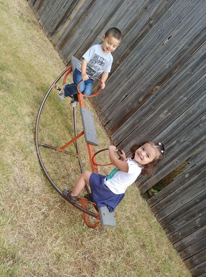 Two children on a playground merry-go-round