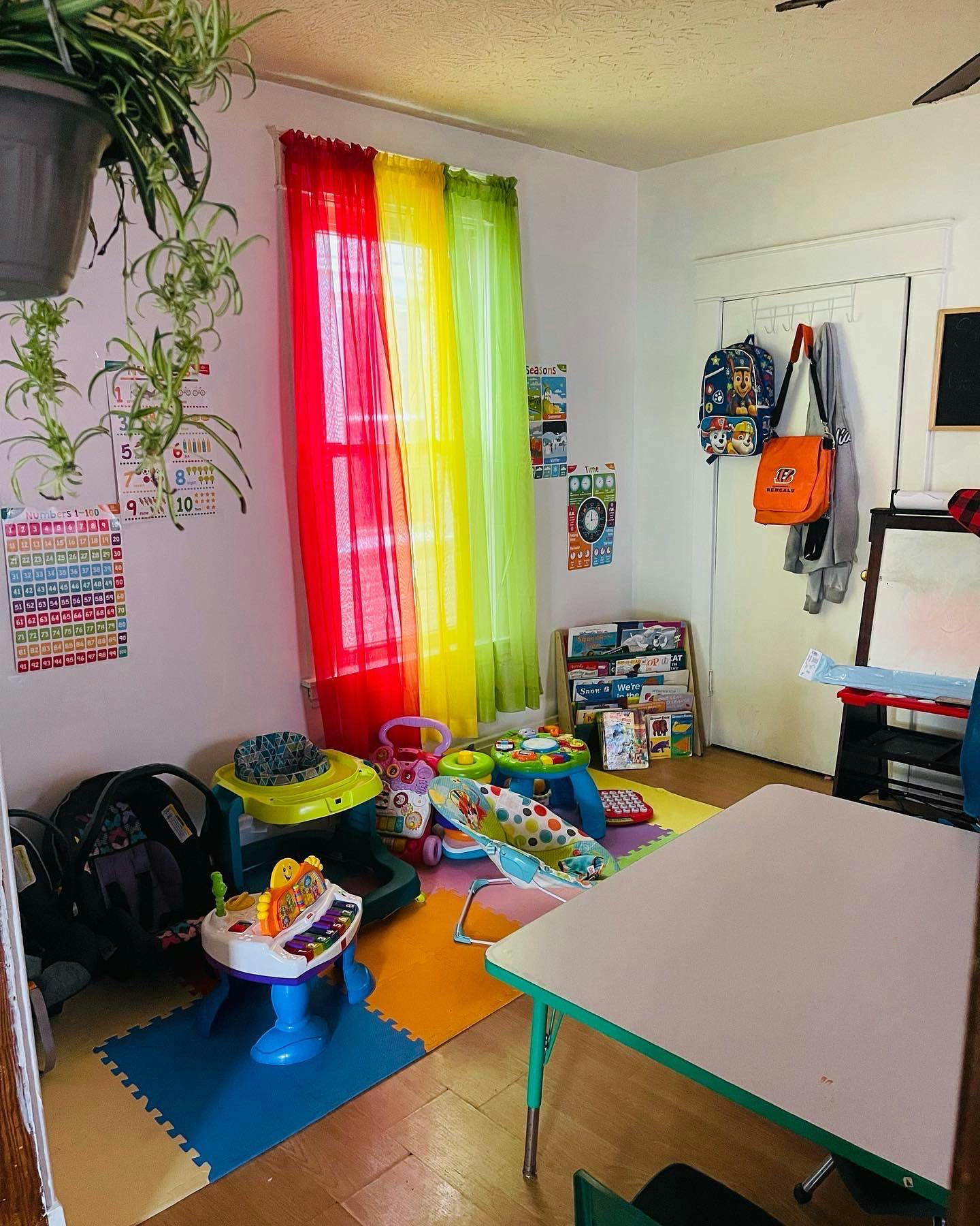 Playroom with colorful curtains, toys, and a small table
